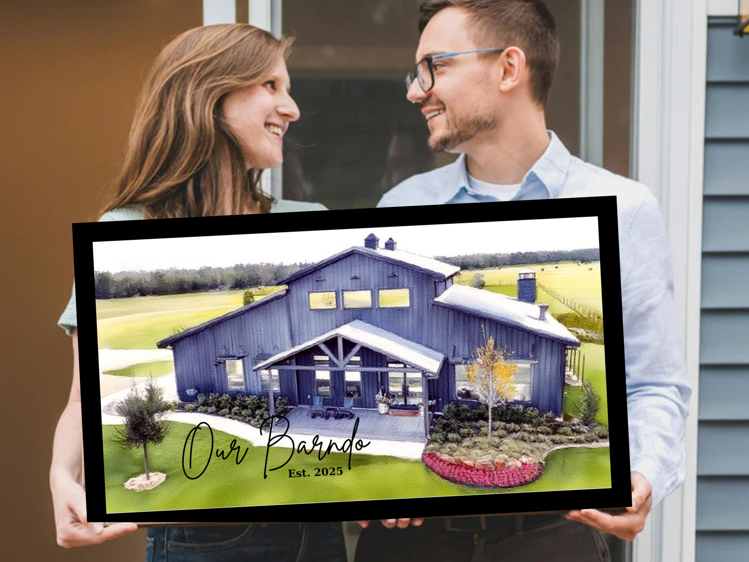 Man and woman holding a framed picture of a barn with 'Our Barndo' text.